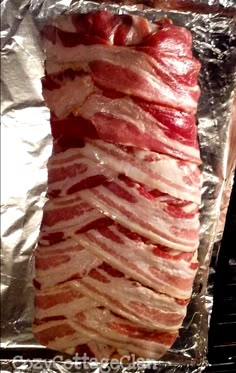 bacon wrapped in aluminum foil sitting on top of an oven