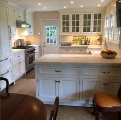 a kitchen with white cabinets and an island