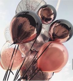 a bunch of balloons that are on top of each other in front of a sky background