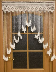 a window with white tassels hanging from it's side