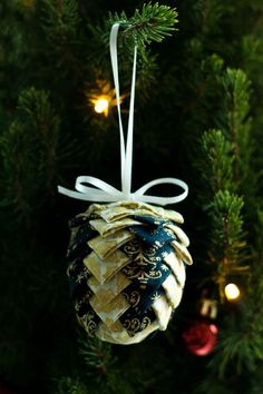 a pine cone ornament hanging from a christmas tree