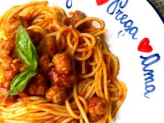 spaghetti with meat sauce and basil leaves on a plate that says happy new year's eve