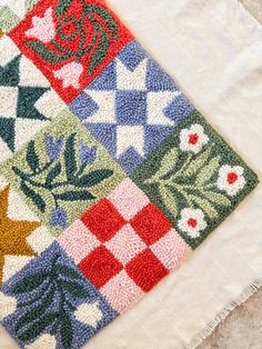 a close up of a piece of cloth with different designs on it, including flowers and leaves