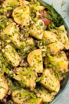 a bowl filled with potatoes and vegetables on top of a table