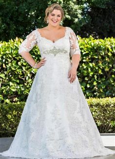 a woman in a wedding dress posing for the camera with her hands on her hips