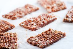 several pieces of food sitting on top of a piece of white paper with brown flakes all over it