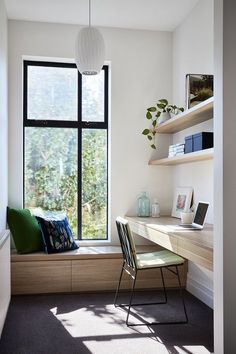 a room with a window, desk and chair next to a book shelf filled with books