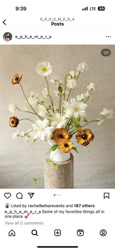 a vase filled with lots of white and yellow flowers