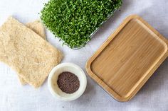 an assortment of food on a table including bread, sprouts and seasoning