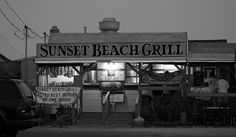 black and white photograph of sunset beach grill