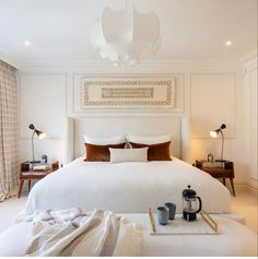 a white bed sitting in a bedroom next to two lamps on either side of it