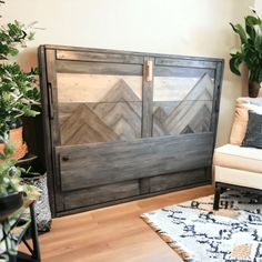 a living room with a white chair and wooden doors on the wall next to potted plants