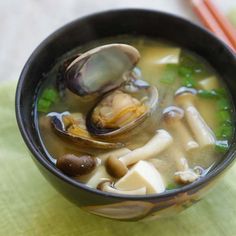 a bowl of soup with clams and vegetables