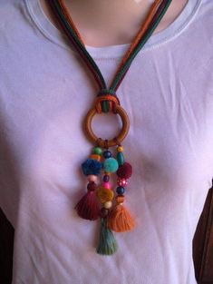 a woman wearing a white t - shirt with a multicolored necklace on her neck