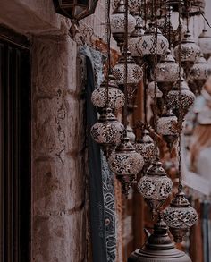 an old lamp hanging from the side of a building with lots of lights on it