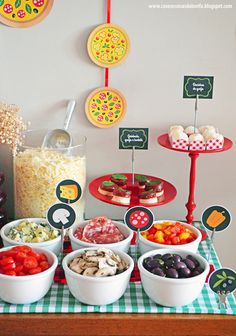 a table topped with bowls of food and plates of food next to cupcakes