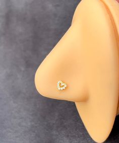 a yellow plastic head with a diamond heart on it's side, sitting on a gray surface