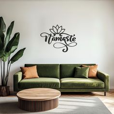 a living room with a green couch and coffee table in front of a white wall