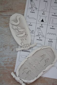 two clay molds sitting on top of a piece of paper next to some drawings