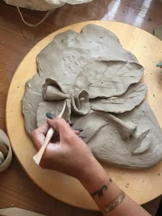 a woman is making clay sculptures on a table