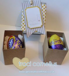 three boxes filled with chocolate eggs sitting on top of a table