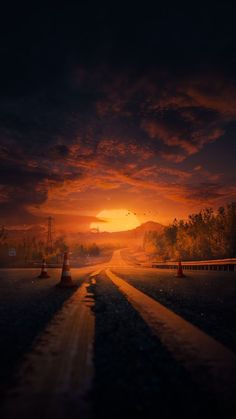 the sun is setting over a road with traffic cones on both sides and trees in the distance