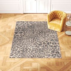 a leopard print rug in a living room with a yellow chair and side table on the floor