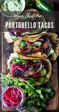 three tacos are sitting on a cutting board with sauces and herbs around them