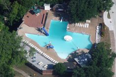 an aerial view of a swimming pool surrounded by trees