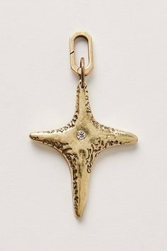 a gold starfish charm with a diamond in it's center on a white background