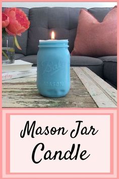 a blue mason jar sitting on top of a wooden table next to a pink flower