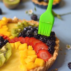 a fruit tart with a green brush sticking out of it