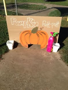 there is a sign that says pumpkin rutt putt on the ground next to buckets