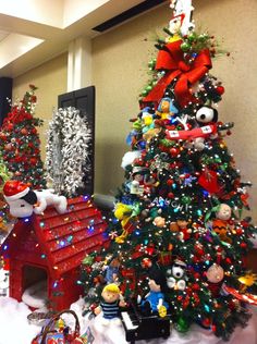 several christmas trees and decorations in an office building