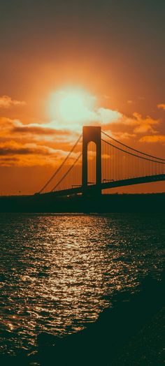 the golden gate bridge is silhouetted against an orange sunset