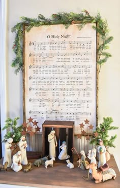 the nativity scene is displayed in front of a large sheet of music and christmas decorations