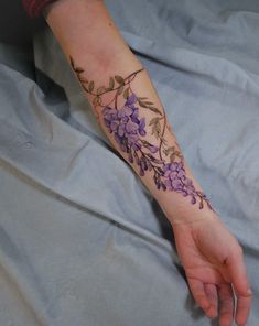 a woman's arm with purple flowers on it