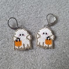 two white sheep earrings with orange beaks on them