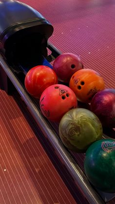 several bowling balls are lined up in a row