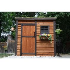 a small wooden shed sitting next to a fence