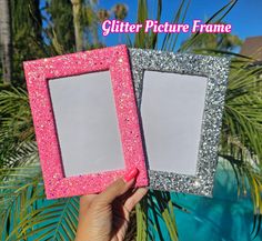 two pink and silver glitter picture frames sitting next to each other with palm trees in the background