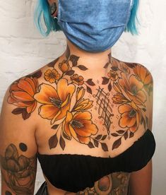 a woman with blue hair and tattoos on her chest wearing a face mask to protect herself from the sun