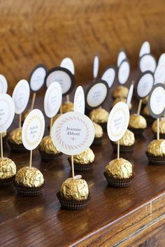 there are many small cupcakes on top of each other with gold foil wrappers