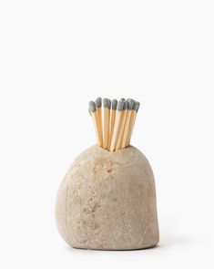 several matches are sticking out of the top of a rock shaped like a vase with four sticks sticking out of it