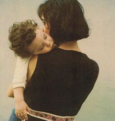 a woman holding a child in her arms