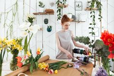 a young woman is making flowers in her home studio while using a camera to take pictures