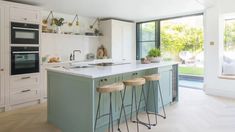 a kitchen with an island and three stools