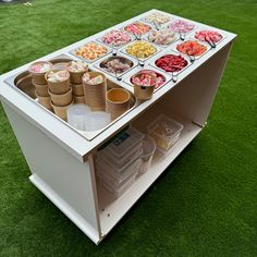 an ice cream stand with lots of different types of desserts on top of it