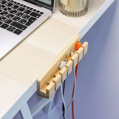 a laptop computer sitting on top of a desk next to an electrical outlet and plugged in