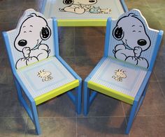 three children's chairs with cartoon characters painted on them, sitting in front of a table